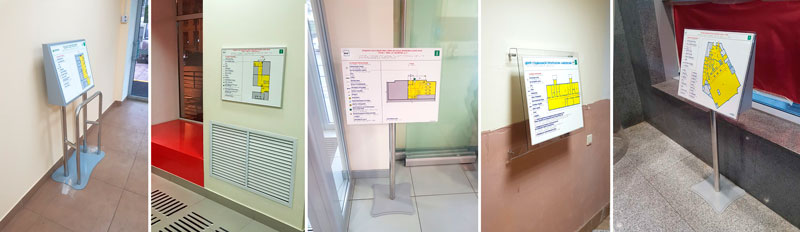 Две мнемосхемы рядом. Левая — цветная, серии «Эконом» (глянцевая, яркая). Правая — строгая монохромная, с ABS-покрытием (матовая, тактильно более плотная). В кадре видна рука человека, проводящая пальцем по шрифту Брайля на обеих табличках. Задача фото — показать, что тактильность есть у обоих вариантов, но исполнение разное.